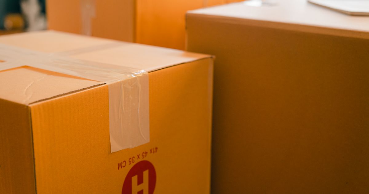 窓辺に置かれた引越し用の段ボール箱(イメージ)